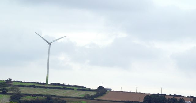 Rural Landscape with Wind Turbine and Cropland Under Cloudy Sky - Download Free Stock Images Pikwizard.com