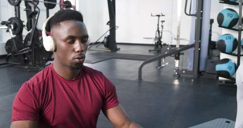 Man meditating with headphones in gym for mindfulness