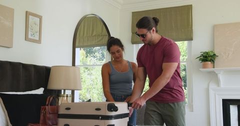 Couple packing suitcase in bedroom for exciting travel adventure