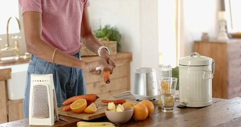 Young Woman Prepares Healthy Carrot Snack in Rustic Farmhouse Kitchen