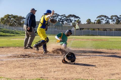 Sliding into home plate during close play with catcher blocking and umpire calling