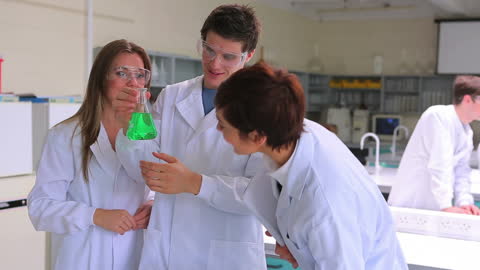 Scientists Examining Green Liquid in Laboratory Discussion