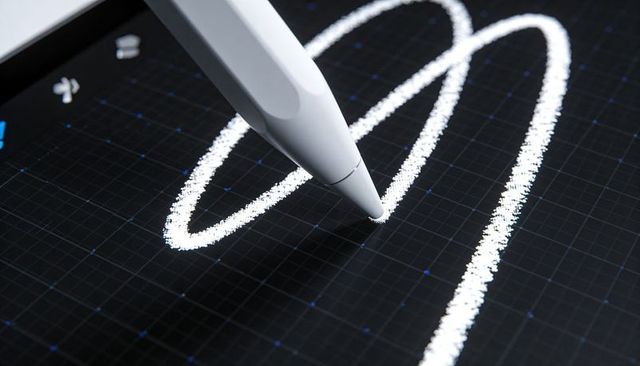 Macro stylus drawing textured white stroke on dark grid touchscreen for digital creativity