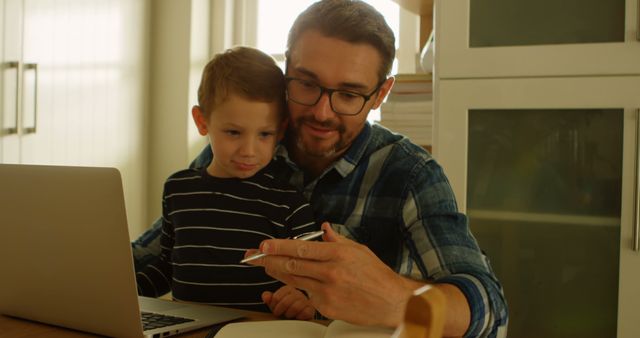 Father working on laptop showing son something interesting - Download Free Stock Images Pikwizard.com