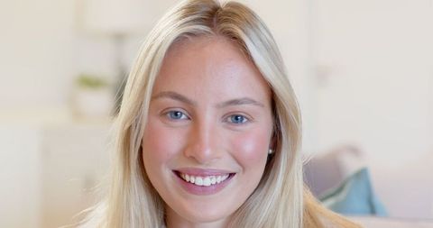 Smiling Blonde Woman Relaxing in Cozy Living Room