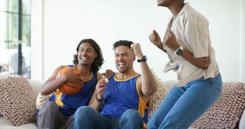 African friends cheering together wearing team jerseys with basketball celebrating victory