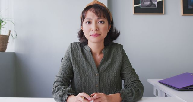 Portrait of biracial businesswoman having image call and looking at camera at office. Work at a modern office.