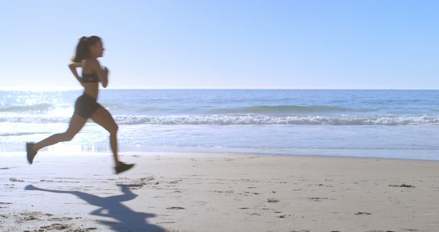 Woman Jogging on Beach During Sunny Day - Download Free Stock Images Pikwizard.com