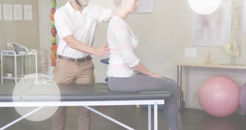Physical therapist guiding seated woman through posture assessment on treatment table