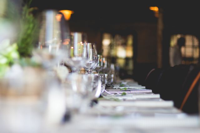 Close up view of multiple glasses and table cloth on a table at restaurant. food and restaurant concept 