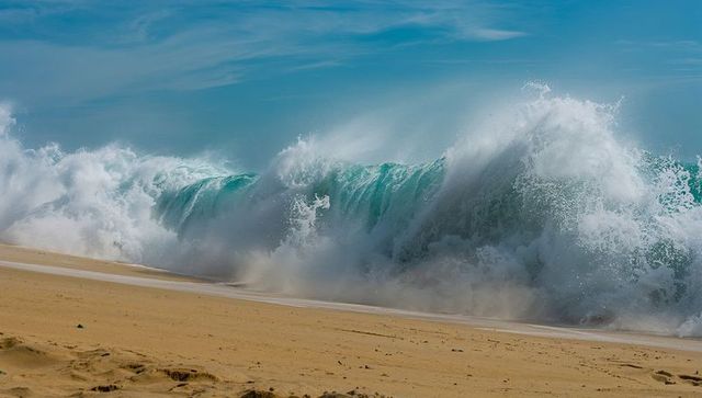 Powerful Ocean Wave Crashing on Sandy Beach