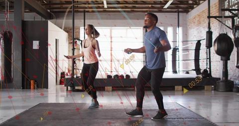 Couple jumping rope for cardio and conditioning in urban boxing gym during partner workout
