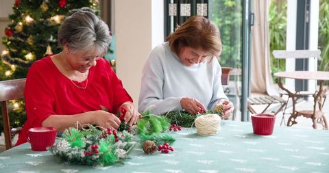Mother and Daughter Crafting Holiday Wreaths Together at Home