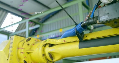 Yellow robotic arm rotating joint with blue hose and gauge in industrial automation