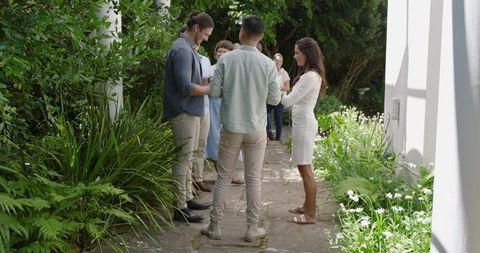 Guests Mingling in Lush Garden at Outdoor Wedding Celebration