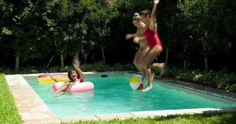 Diverse Friends Enjoying Pool Fun with Inflatable Float and Beach Ball