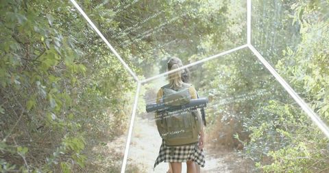 Backpacker walking forest trail with cap and waist-tied shirt, code hex-grid overlay
