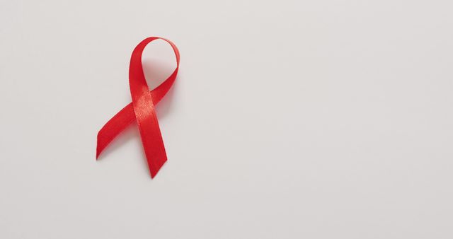 Red awareness ribbon symbolizing support and activism for health-related causes, particularly HIV/AIDS. Suitable for health campaigns, charity events, promotional materials, healthcare advocacy, social media posts, and educational content.