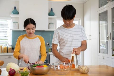 Couple preparing fresh ingredients together in kitchen