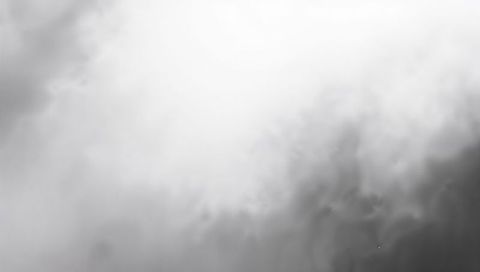 Monochrome clouds forming luminous center with shadowed lower-right depth