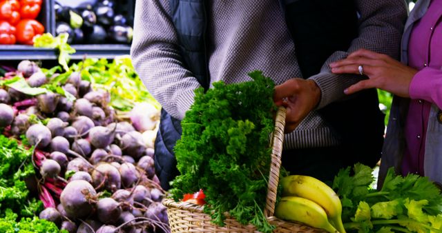Couple selecting vegetables from organic section in supermarket