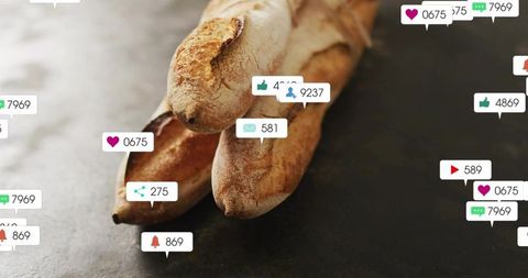 Rustic baguettes receiving social notifications over dark slate surface showing online buzz
