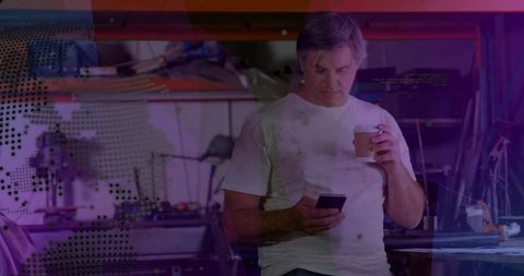 Mature technician engaging with digital technology in industrial workspace