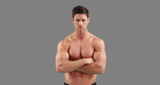 Muscular Male with Arms Crossed on Gray Background - Download Free Stock Images Pikwizard.com