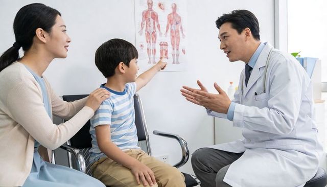 Pediatrician consulting with child pointing at anatomical chart during family clinic visit