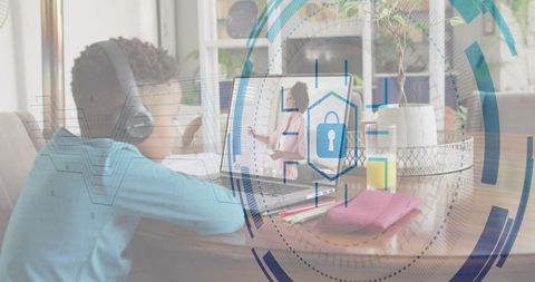 Child learning remotely at home on laptop wearing headset with digital security overlay