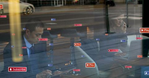 Executives working in cafe using laptop tablet phone with floating social icons