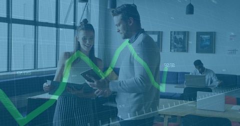 Manager and Intern Analyzing Data on Tablet in Modern Office Lounge