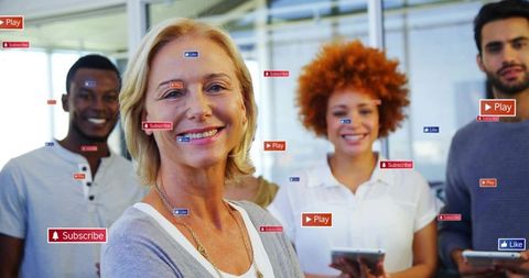 Smiling leader guiding diverse digital team using tablets with social media icons overlay