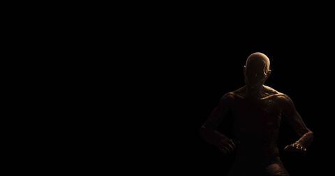 Distressed figure in dark room expressing inner torment