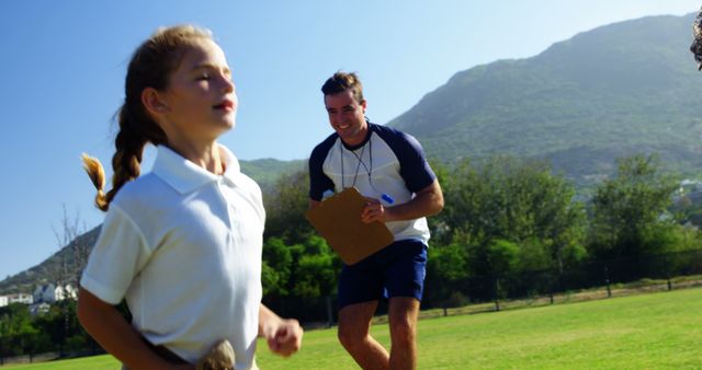 Coach Encouraging Young Girl Running in Park - Download Free Stock Images Pikwizard.com