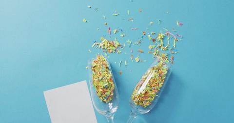 Colorful Confetti in Champagne Glasses on Blue Background