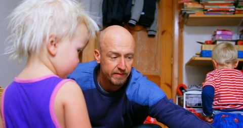 Father and Children Engaging in Home Activities inside Cozy Room