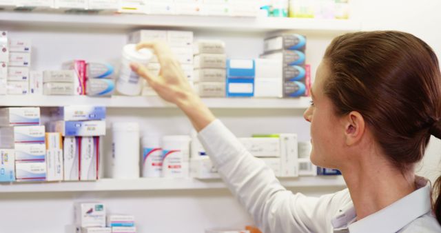 Pharmacist checking medicine in shelf at pharmacy