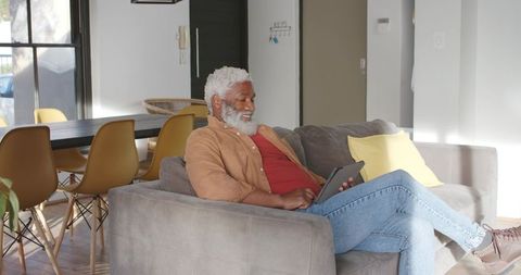 Elderly Man Relaxing with Tablet in Contemporary Living Room
