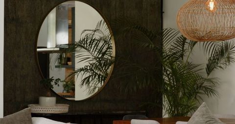 Round mirror and botanical elements in modern cozy living room