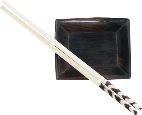 Transparent chopsticks resting on elegant black ceramic plate