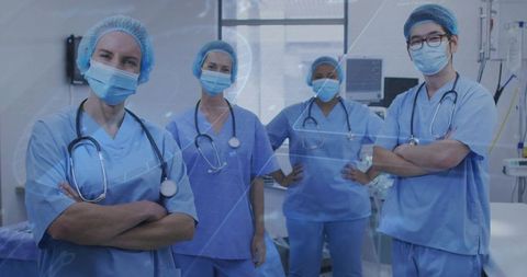 Multidisciplinary medical team standing confident in blue scrubs and masks in clinical room
