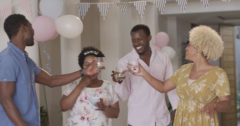 Friends celebrating at home with drinks and laughter