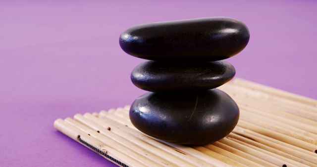 Balancing Black Zen Stones on Bamboo Mat with Purple Background - Download Free Stock Images Pikwizard.com