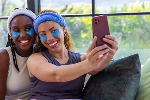 African american friends taking selfie wearing blue eye patches and cozy headbands