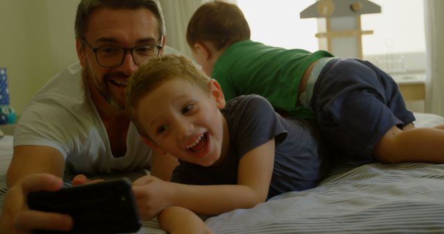 Father and Sons Enjoying Quality Time Together on Bed - Download Free Stock Images Pikwizard.com