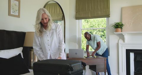 Couple packing luggage in bedroom for travel celebration preparation