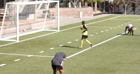 Young Soccer Player Running on Football Pitch during Training