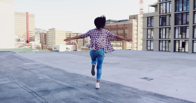 Young Woman Joyfully Running on Urban Rooftop - Download Free Stock Images Pikwizard.com