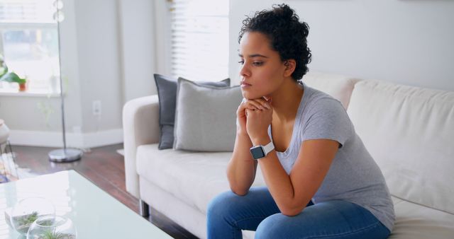 Thoughtful Woman Sitting on Sofa in Modern Living Room - Download Free Stock Images Pikwizard.com